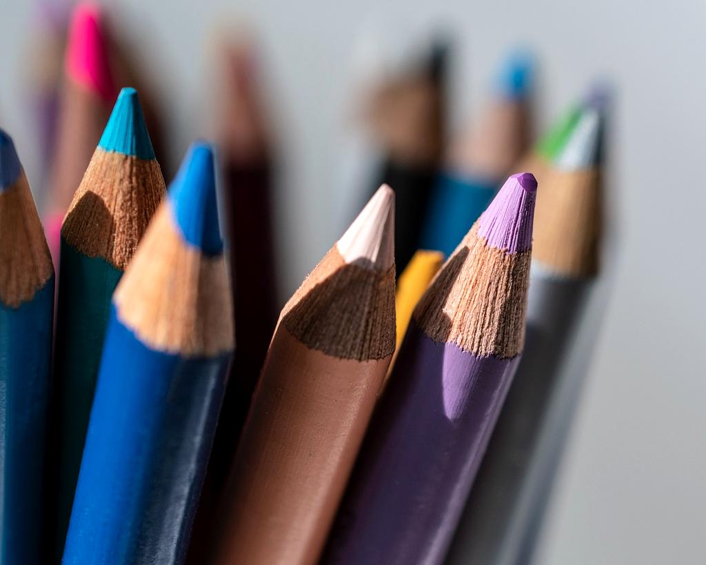 Art supplies and sketchbooks arranged on wooden table